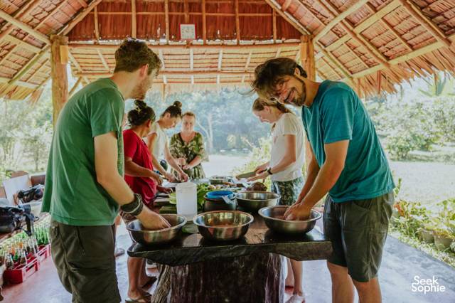 Reizigers koken samen onder het rieten afdak van Rungfah Farm Stay in Khao Sok