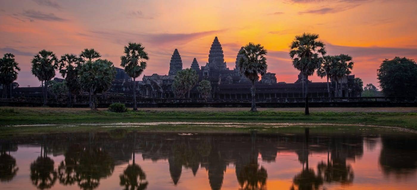 Silhouet van Angkor Wat bij zonsopgang, weerspiegeld in het water