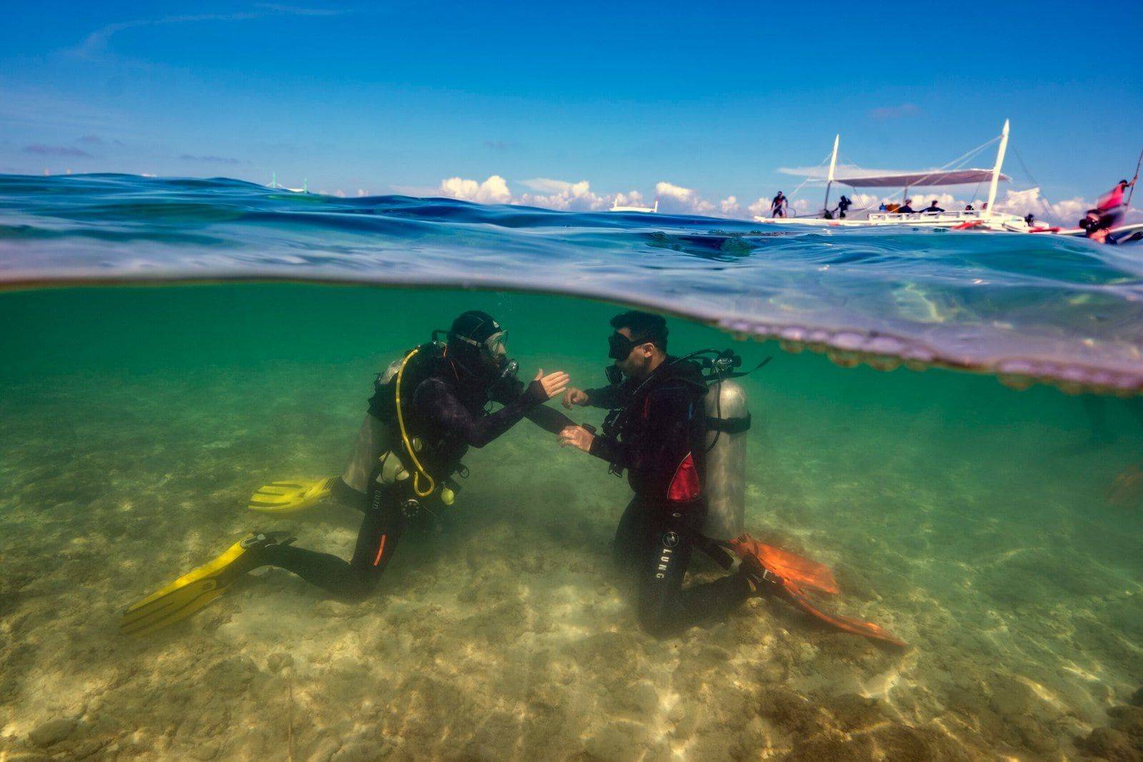 Instructeur en cursist oefenen in het ondiepe water van Panagsama Beach