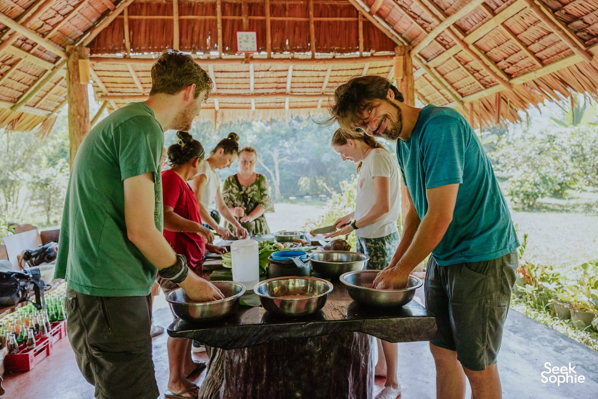 Reizigers koken samen onder het rieten afdak van Rungfah Farm Stay in Khao Sok