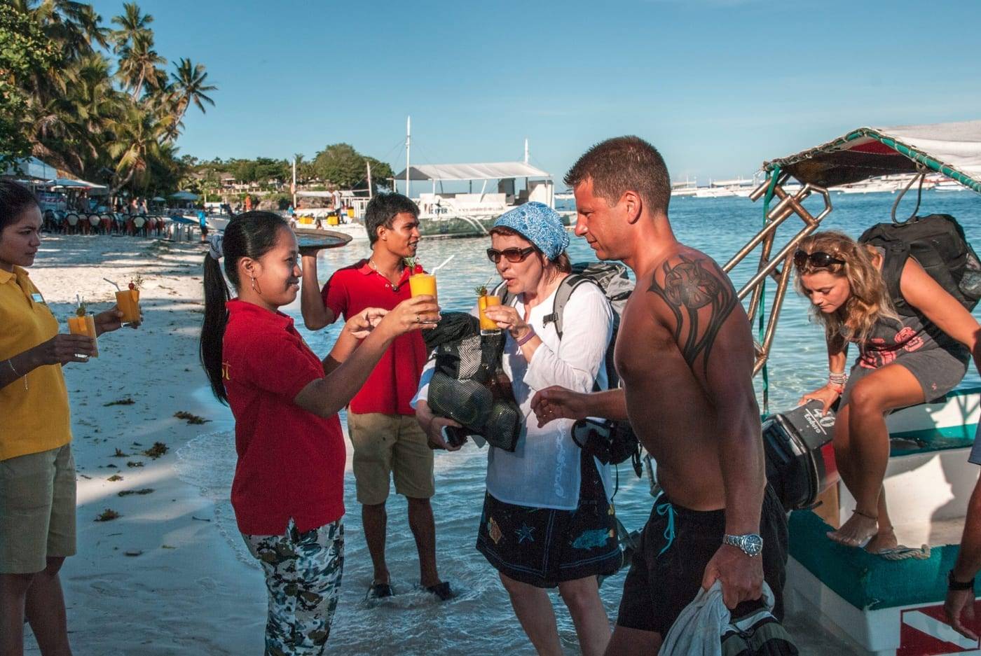 Het team van Seaquest ontvangt duikers met een drankje op het strand
