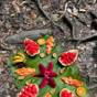 Een bord met vers fruit, in patronen gelegd op een bananenblad