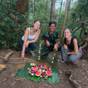 Twee trekkers en hun gids met een fruitbord midden in de jungle