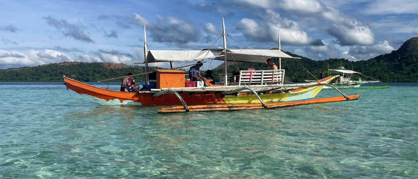 Traditionele Filipijnse bangka-boot op helder turquoise water